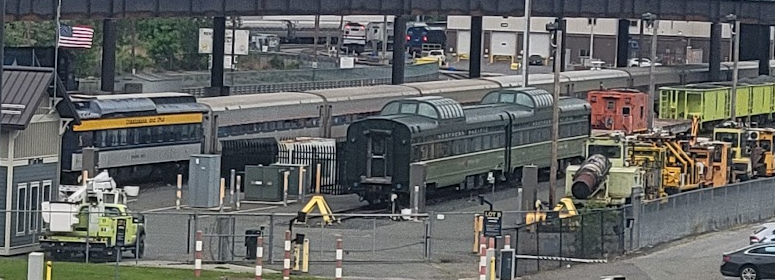 photo of some unknown heritage cars seen in a busy Amtrak railyard